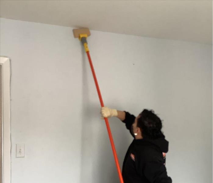 A SERVPRO professional using a chemical sponge to clean soot